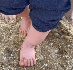 petits pieds de bébé dans le sable